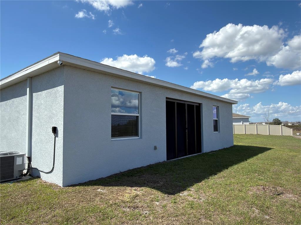 The exterior of a house features a garage, stone accents, and a light-colored stucco finish — 521 REGGIE ROAD, WINTER HAVEN, FL