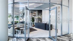 This is a rendering of a modern lobby with a reception desk and glass entrance doors — 301 QUAY COMMONS UNIT 904, SARASOTA, FL