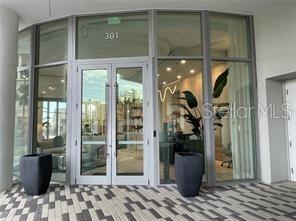 A glass-paneled double door entrance with a number 301 sign and two large planters — 301 QUAY COMMONS UNIT 904, SARASOTA, FL