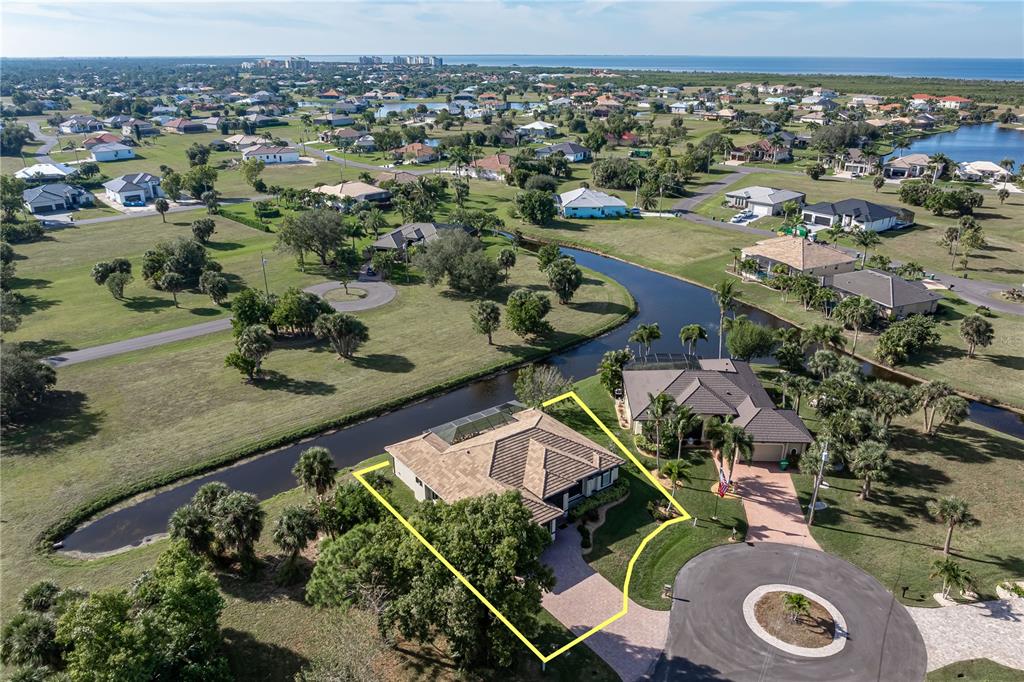 An aerial view shows a residential house with a tiled roof situated on a canal — 17157 MINT LANE, PUNTA GORDA, FL