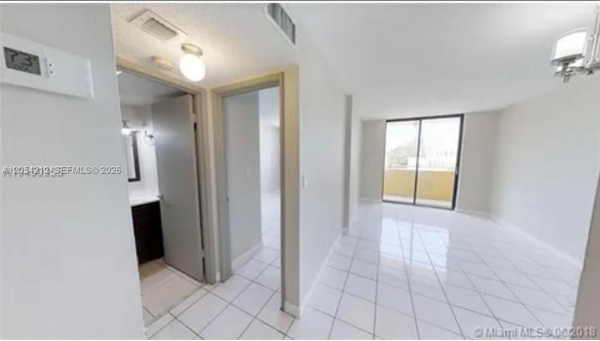 An interior view shows a tiled hallway leading to a living area with a balcony — 501 SW 1st St # 311, Miami FL 33130, MIAMI, FL