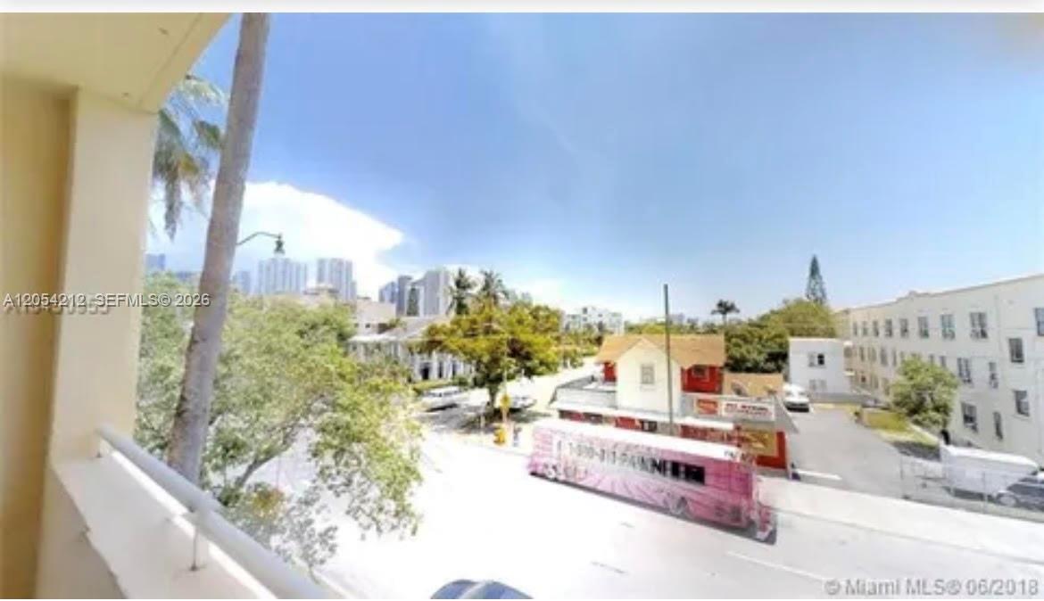 An elevated view from a balcony overlooking a street, trees, and nearby buildings — 501 SW 1st St # 311, Miami FL 33130, MIAMI, FL