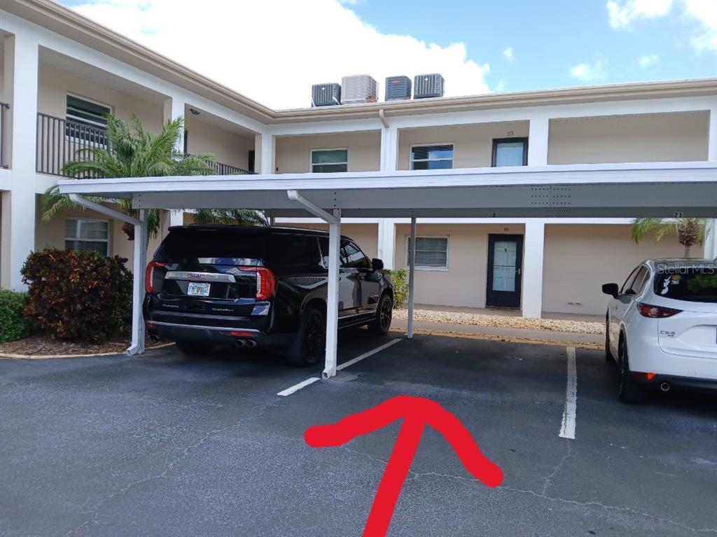 A black SUV and a white car are parked under a covered carport at an apartment — 10350 IMPERIAL POINT DRIVE W UNIT 8, LARGO, FL
