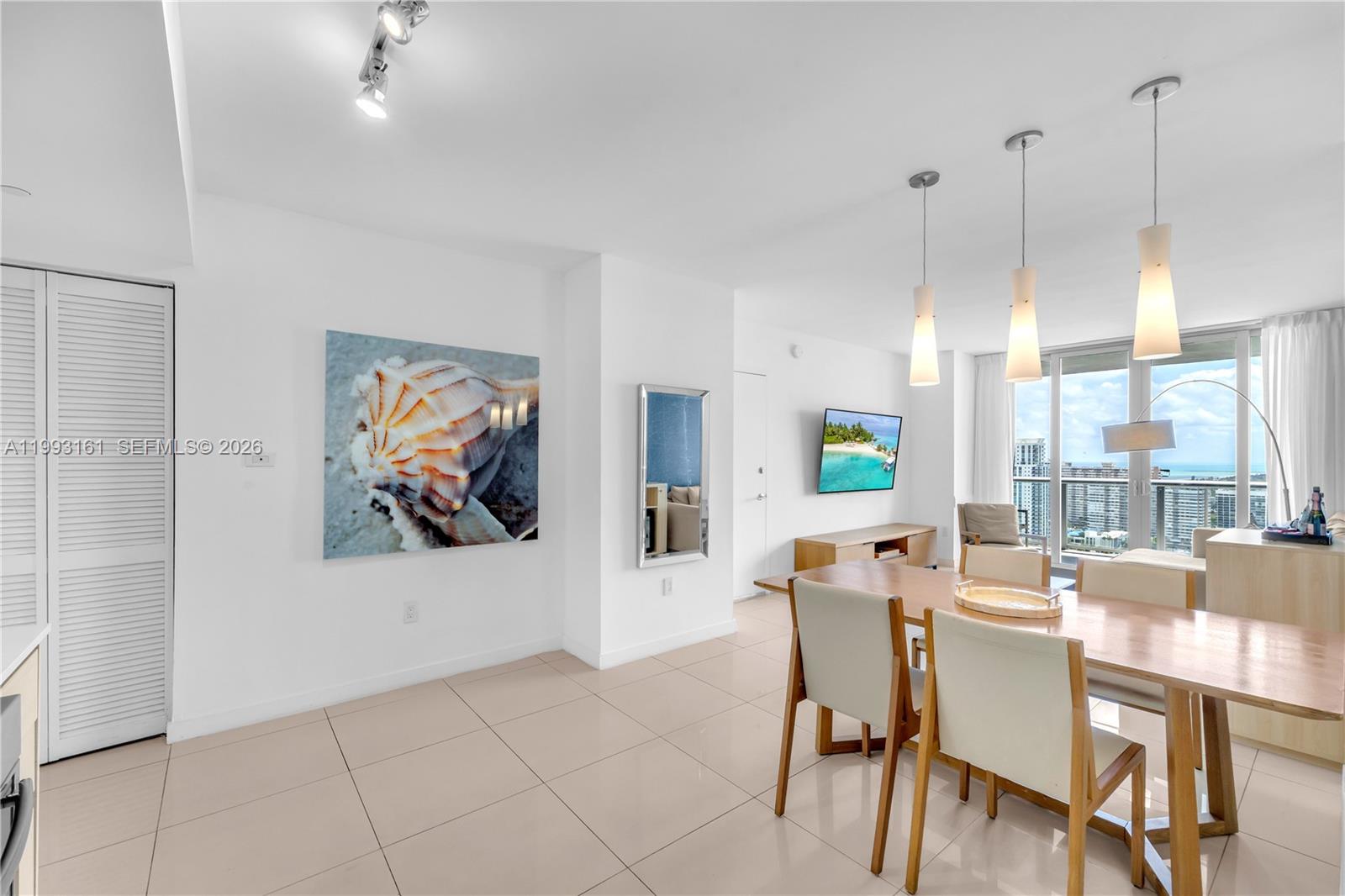 A bright dining area features tile floors, pendant lighting, and a view of the ocean — 2602 E Hallandale Beach Blvd # R2805, Hallandale Beach FL 33009, HALLANDALE BEACH, FL