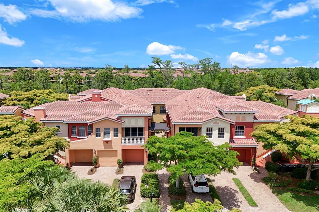 An aerial view of a multi-unit residential building with a tiled roof and garages — 8721 PIAZZA DEL LAGO CIRCLE UNIT 205, ESTERO, FL