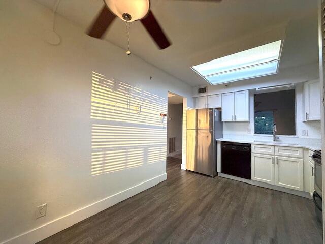 A kitchen and dining area with white walls, wood-look flooring, and a skylight — 4570 NW 18th Avenue # 609, Deerfield Beach FL 33064, DEERFIELD BEACH, FL