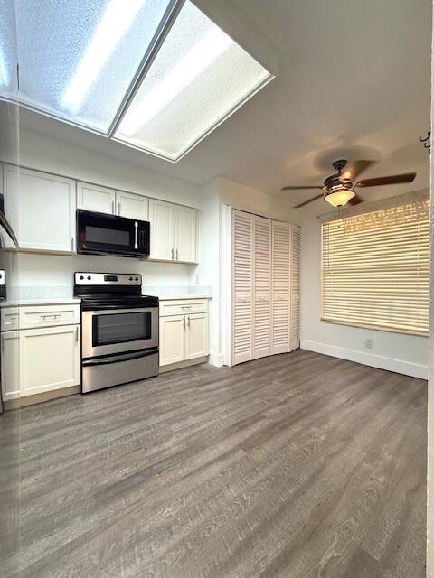 A kitchen features white cabinetry, stainless steel appliances, a ceiling fan, and wood-look flooring — 4570 NW 18th Avenue # 609, Deerfield Beach FL 33064, DEERFIELD BEACH, FL