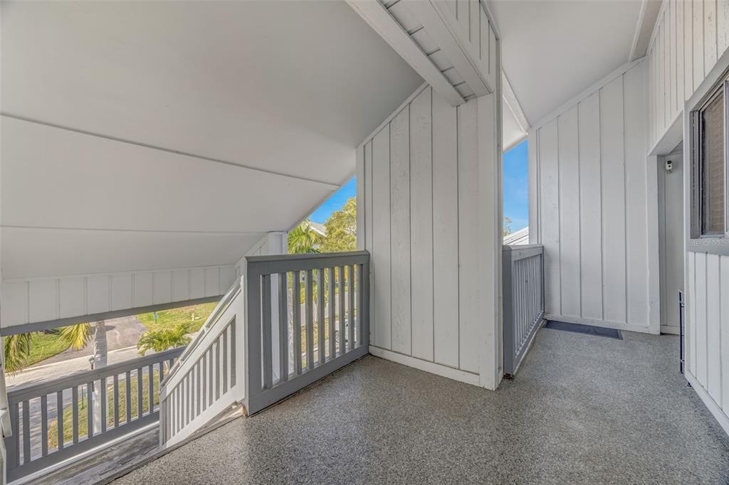 An outdoor balcony with gray railings, a textured floor, and white vertical siding — 803 BAHIA DEL SOL DRIVE UNIT B, RUSKIN, FL