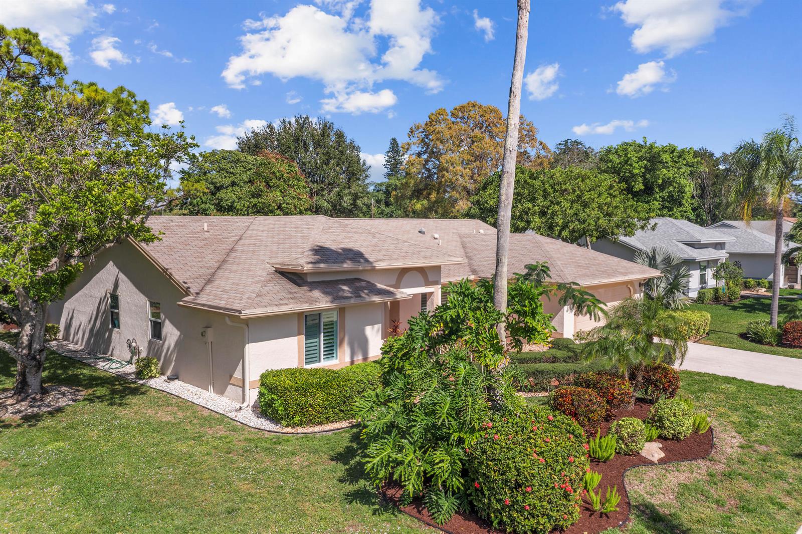 An exterior view of a single-story house with a tan roof and landscaped front yard — 2685 Riviera Drive, Delray Beach FL 33445, DELRAY BEACH, FL