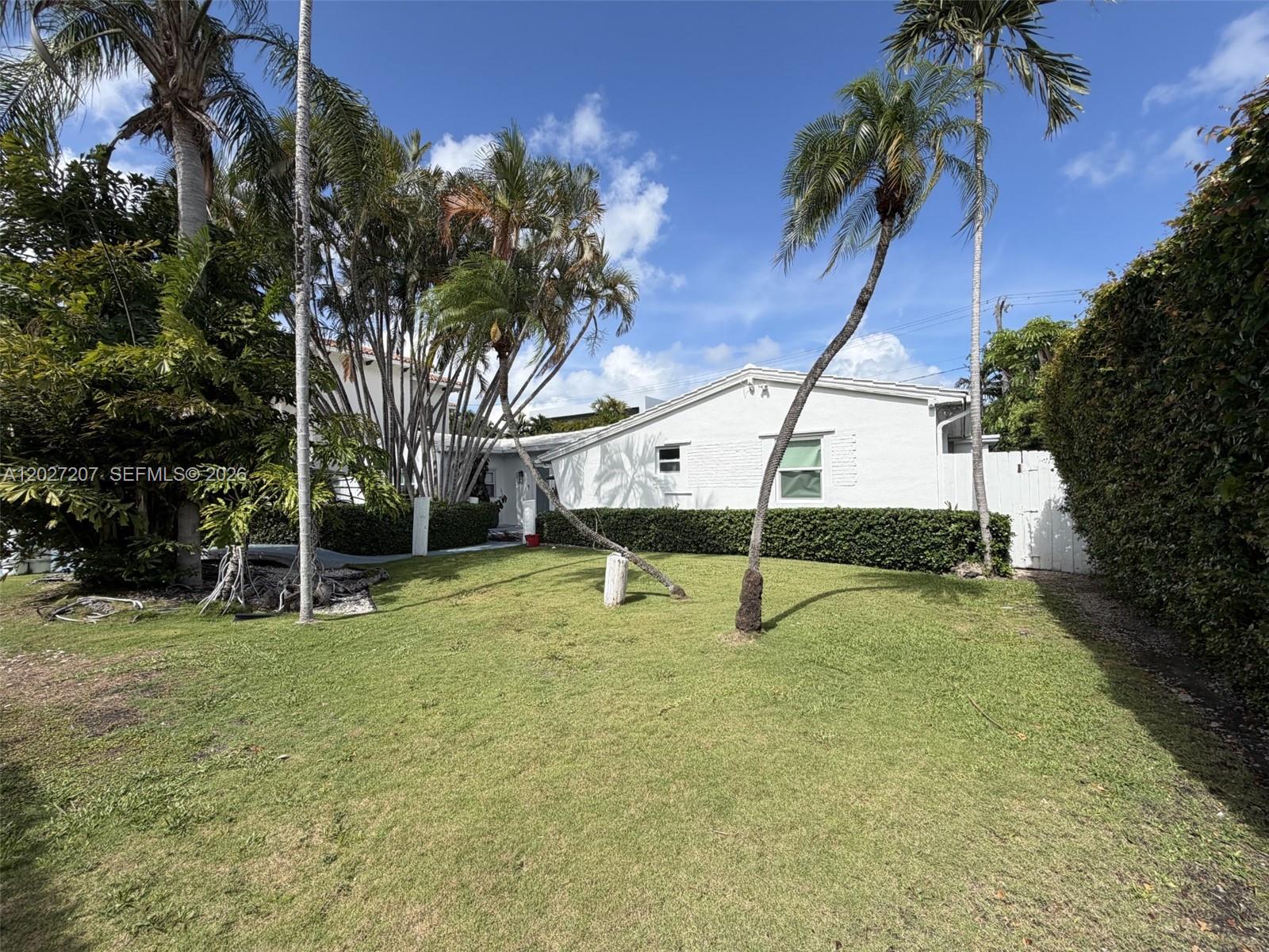 A white house with a green lawn and several palm trees under a blue sky — 665 Allendale Rd, Key Biscayne FL 33149, KEY BISCAYNE, FL