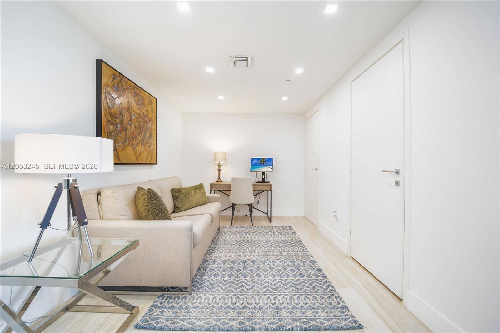 A modern room features a sofa, a desk with a computer, and a patterned rug — 1300 Brickell Bay Dr # 3004, Miami FL 33131, MIAMI, FL