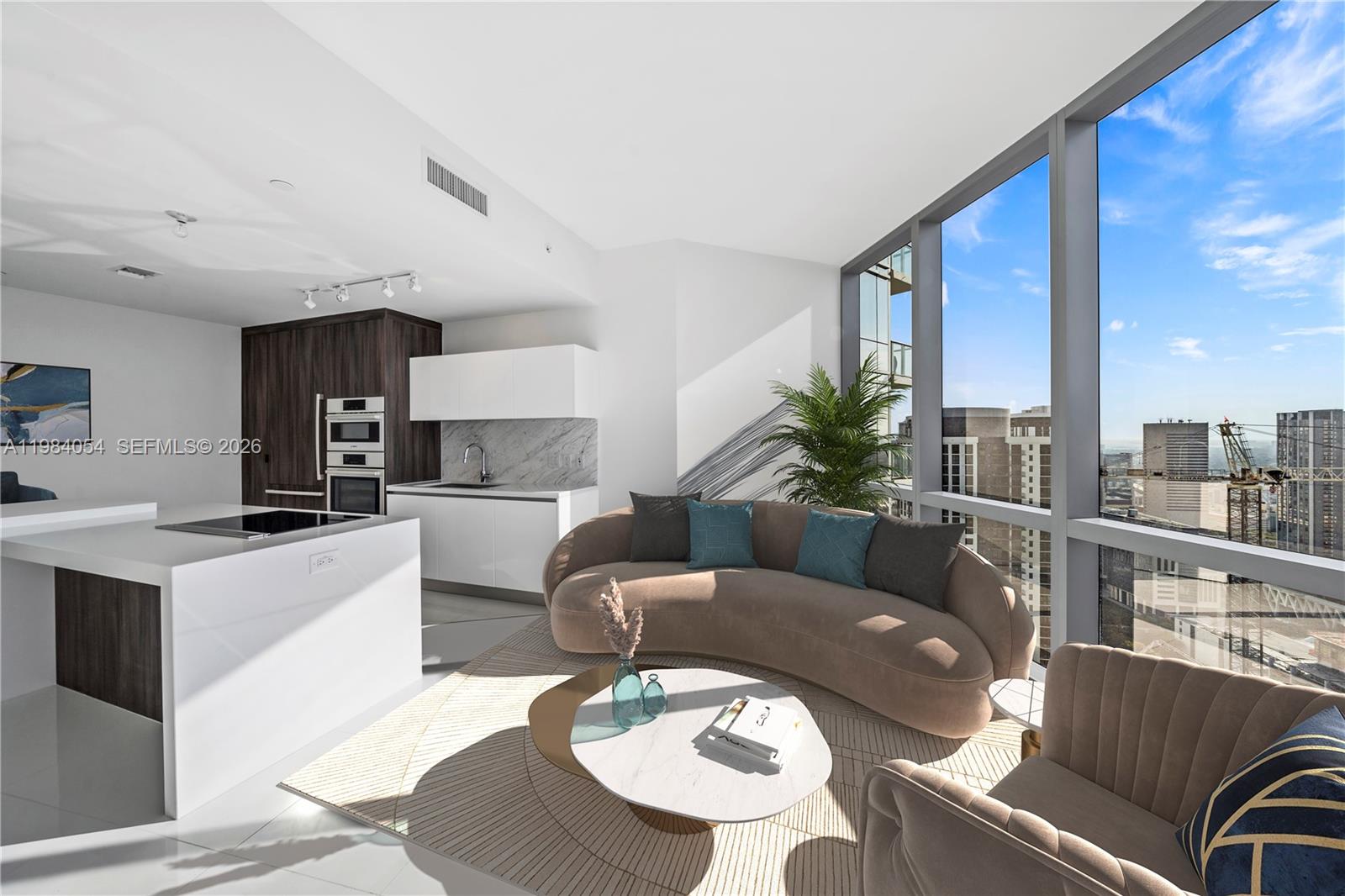 A modern open-concept living room and kitchen featuring floor-to-ceiling windows with city views — 851 NE 1st Ave # 4010, Miami FL 33132, MIAMI, FL