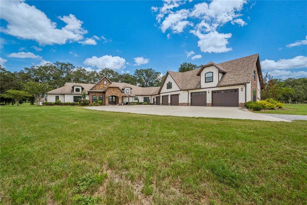 A large multi-car garage home features a stone facade and a sprawling concrete driveway — 4107 SW STATE ROAD 45, NEWBERRY, FL