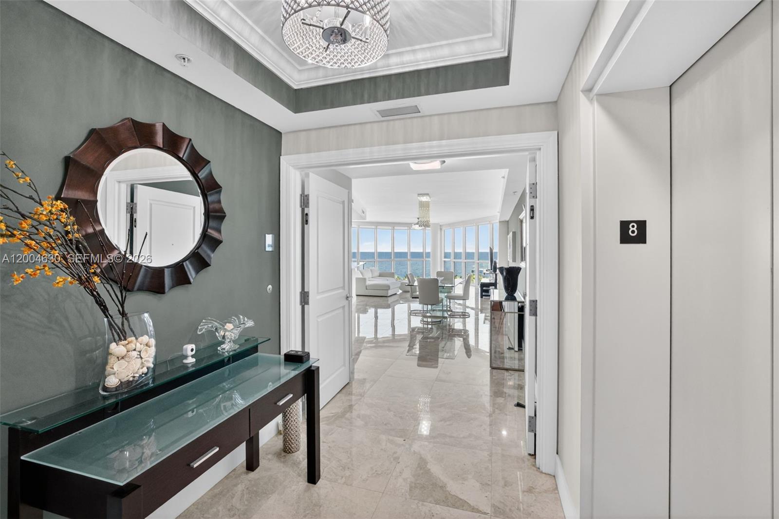 A foyer with a glass console table leads through double doors to an oceanfront living area — 1 N Ocean Blvd # 806, Pompano Beach FL 33062, POMPANO BEACH, FL