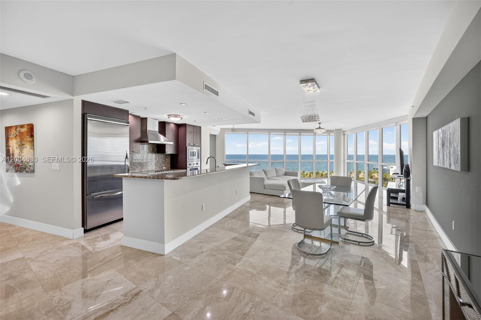 An open-concept kitchen and dining area features marble floors, stainless steel appliances, and ocean views — 1 N Ocean Blvd # 806, Pompano Beach FL 33062, POMPANO BEACH, FL