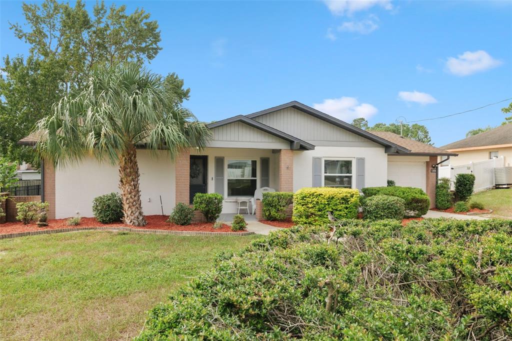 A single-story house with a palm tree, brick accents, and a landscaped front yard — 12056 CRADOCK STREET, SPRING HILL, FL