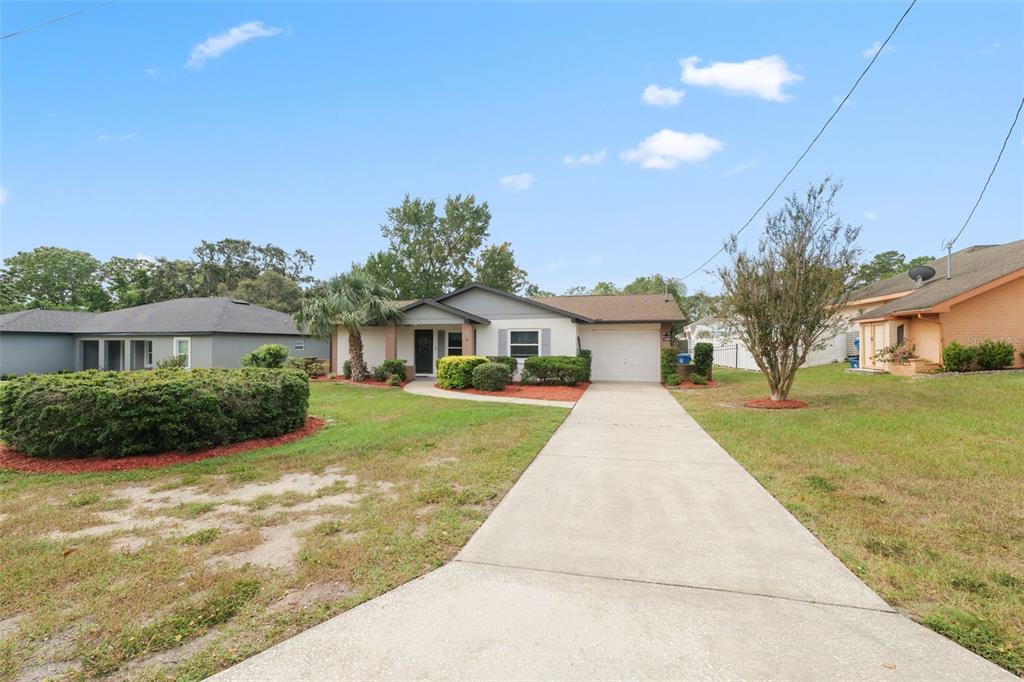 A single-story house with a concrete driveway, a front lawn, and a garage — 12056 CRADOCK STREET, SPRING HILL, FL