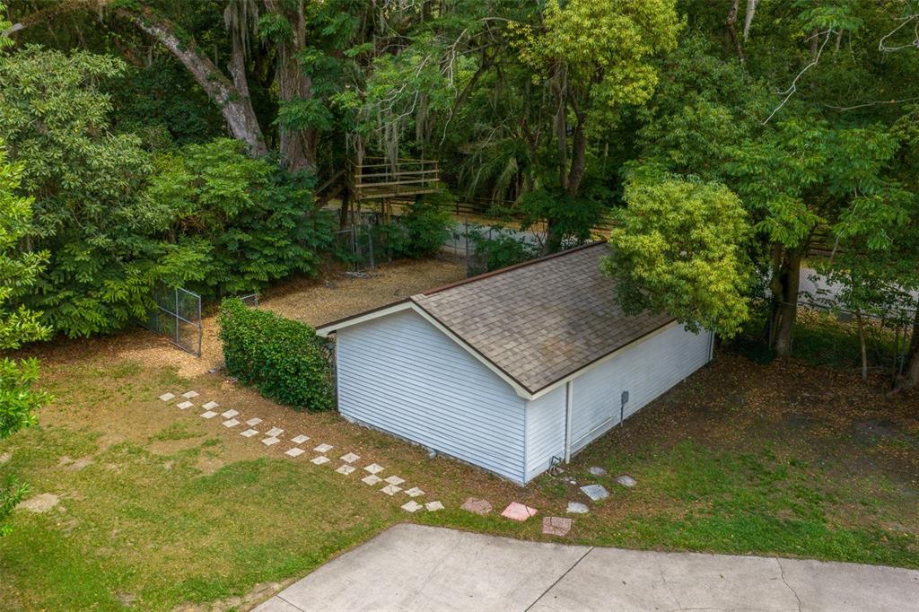 An aerial view shows a detached garage with a shingled roof next to a backyard — 1985 NE 97TH STREED ROAD, ANTHONY, FL