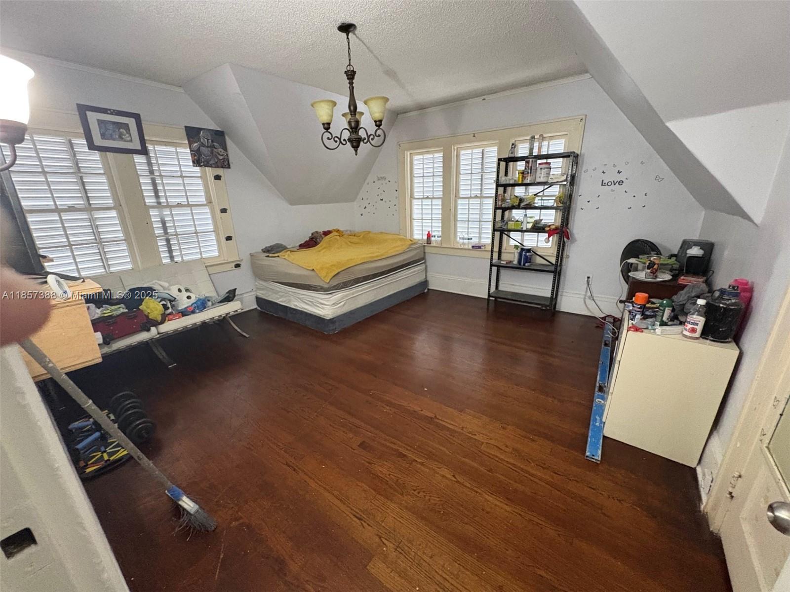 A bedroom with hardwood floors, a mattress on the floor, and a metal shelving unit — 2619 SW 5th St, Miami FL 33135, MIAMI, FL