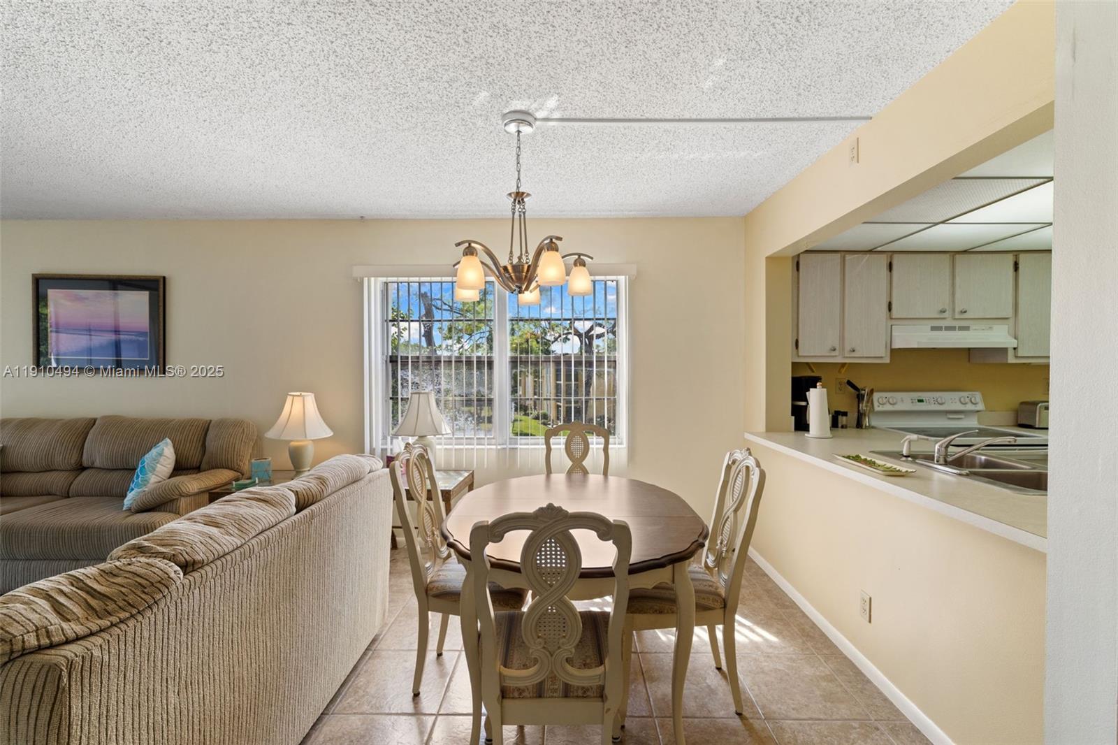 A dining area with a wooden table and chairs sits adjacent to a kitchen counter — 1087 Forest Lakes Drive # 309, Naples FL 34105, NAPLES, FL
