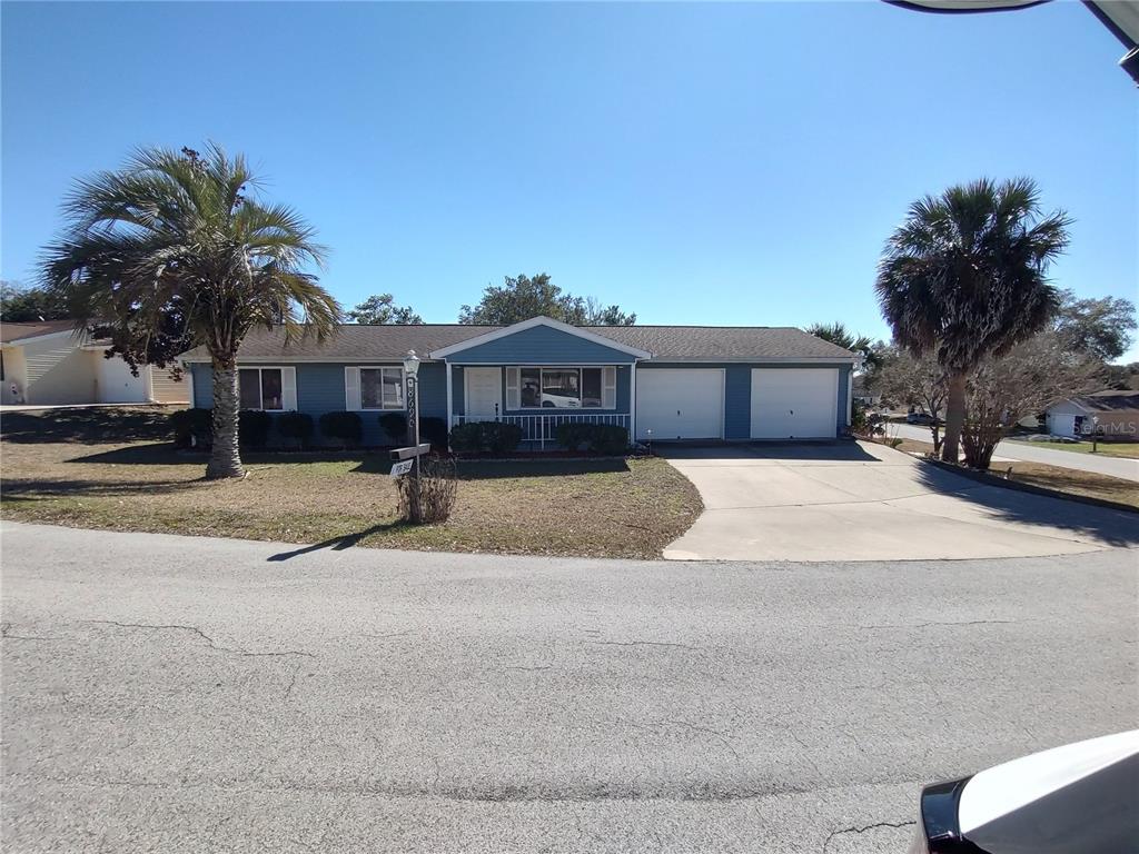 A blue single-story house with a two-car garage and two palm trees in the yard — 8690 SW 108TH PLACE, OCALA, FL
