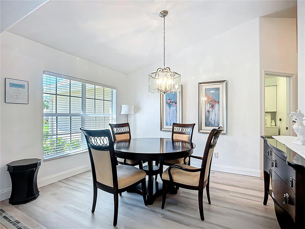 A dining room features a round dark wood table, four chairs, and a hanging chandelier — 123 MARKER ROAD, ROTONDA WEST, FL