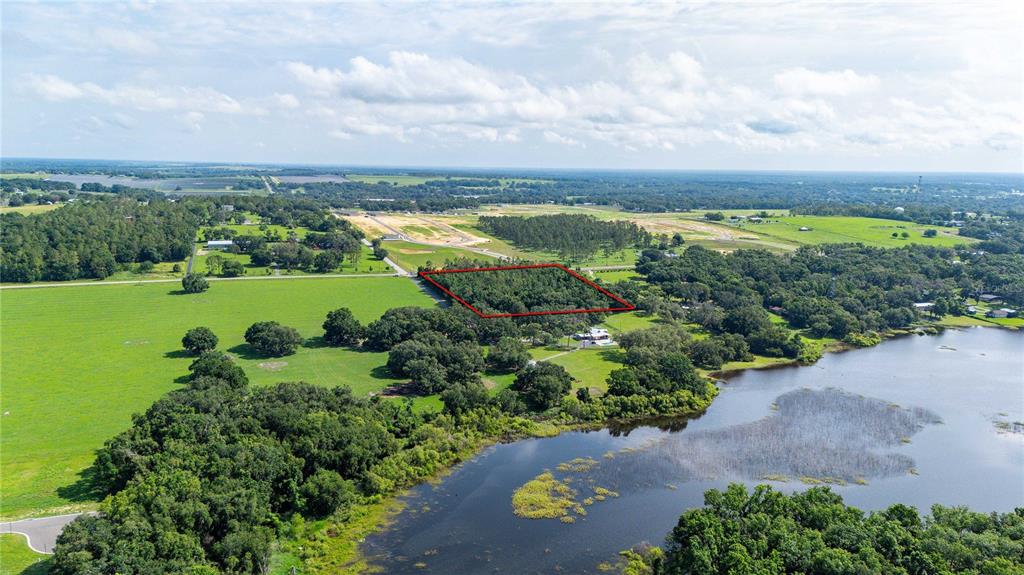 An aerial view shows a rectangular wooded lot outlined in red near a lake — 36126 SAINT JOE ROAD, DADE CITY, FL