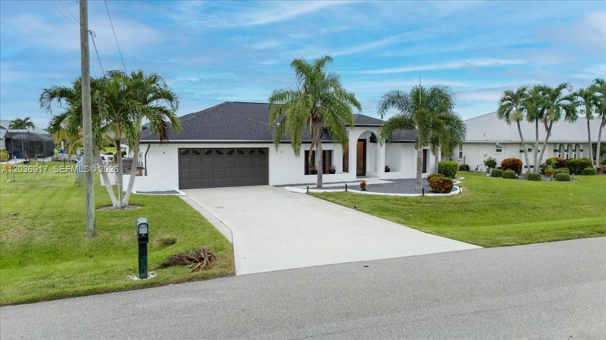 A white single-story house with a dark roof and a concrete driveway sits on grass — 3728 SE 18 Ave, Cape Coral FL 33904, CAPE CORAL, FL