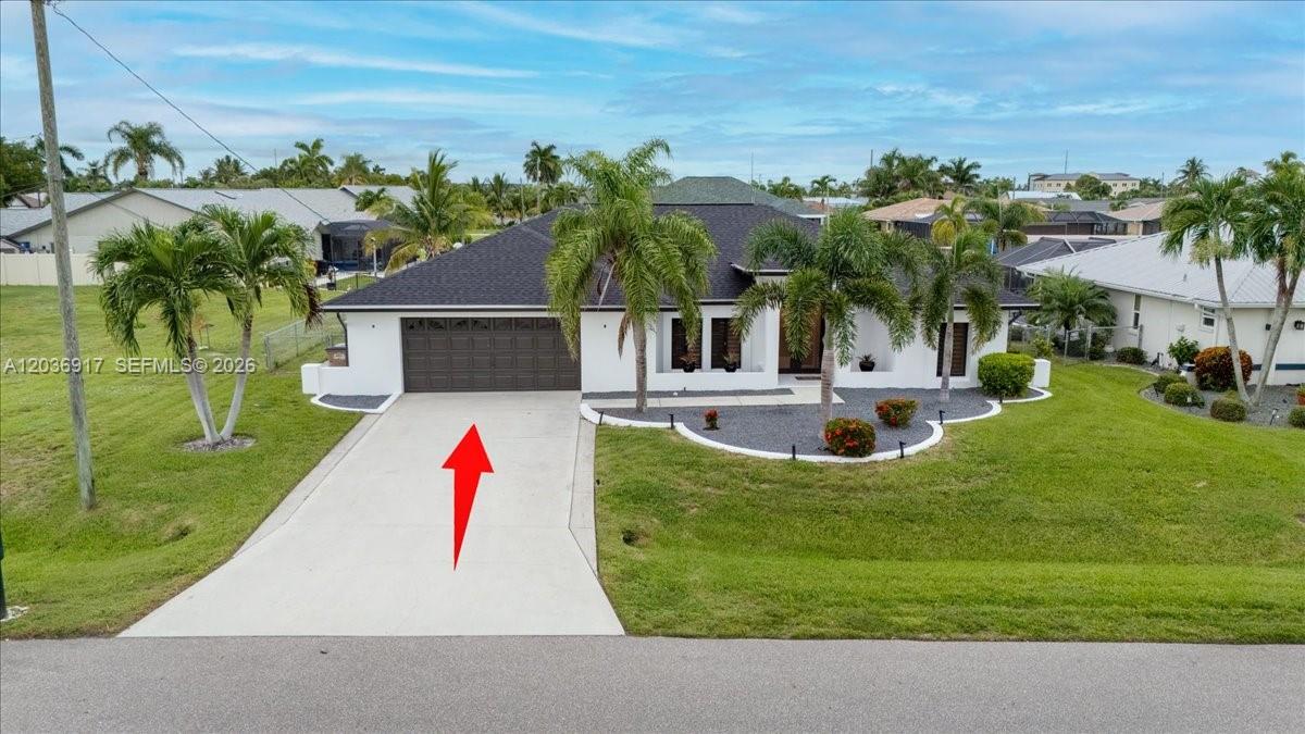 A single-story house with a dark roof, white exterior, and a concrete driveway — 3728 SE 18 Ave, Cape Coral FL 33904, CAPE CORAL, FL