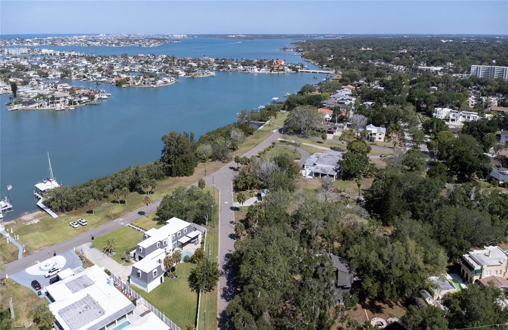 An aerial view shows a coastal neighborhood with houses, a road, and a waterway — 662 VILLAGRANDE AVENUE S, ST PETERSBURG, FL