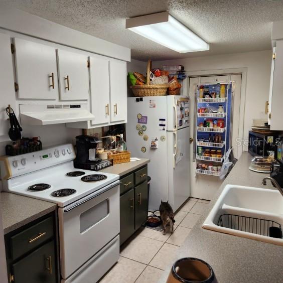 A kitchen features white cabinetry, a white stove, a refrigerator, and a pantry door — 4070 GROBE STREET, NORTH PORT, FL