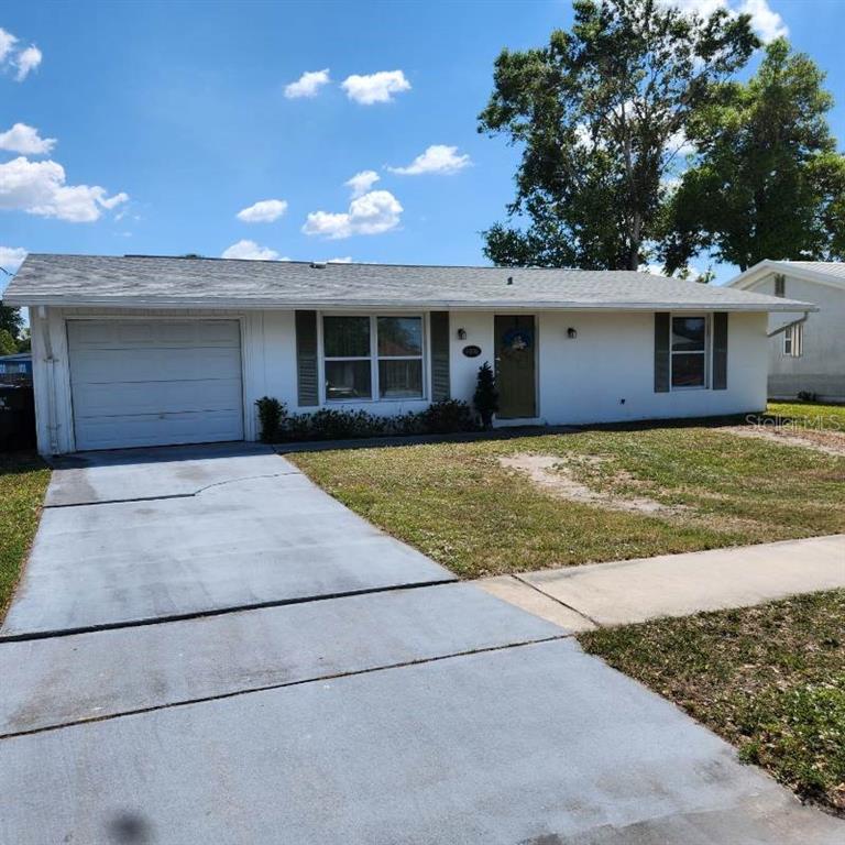 A single-story white house with a garage, a concrete driveway, and a front lawn — 4070 GROBE STREET, NORTH PORT, FL