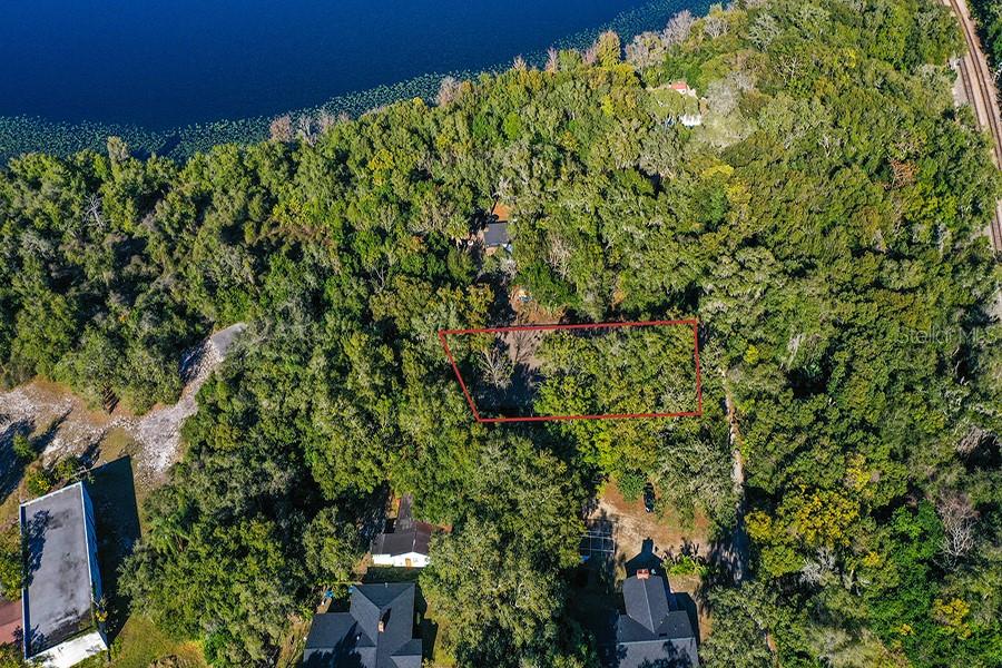 An aerial view shows a rectangular plot of land outlined in red amidst dense trees — 1130 MECHANIC STREET, MAITLAND, FL