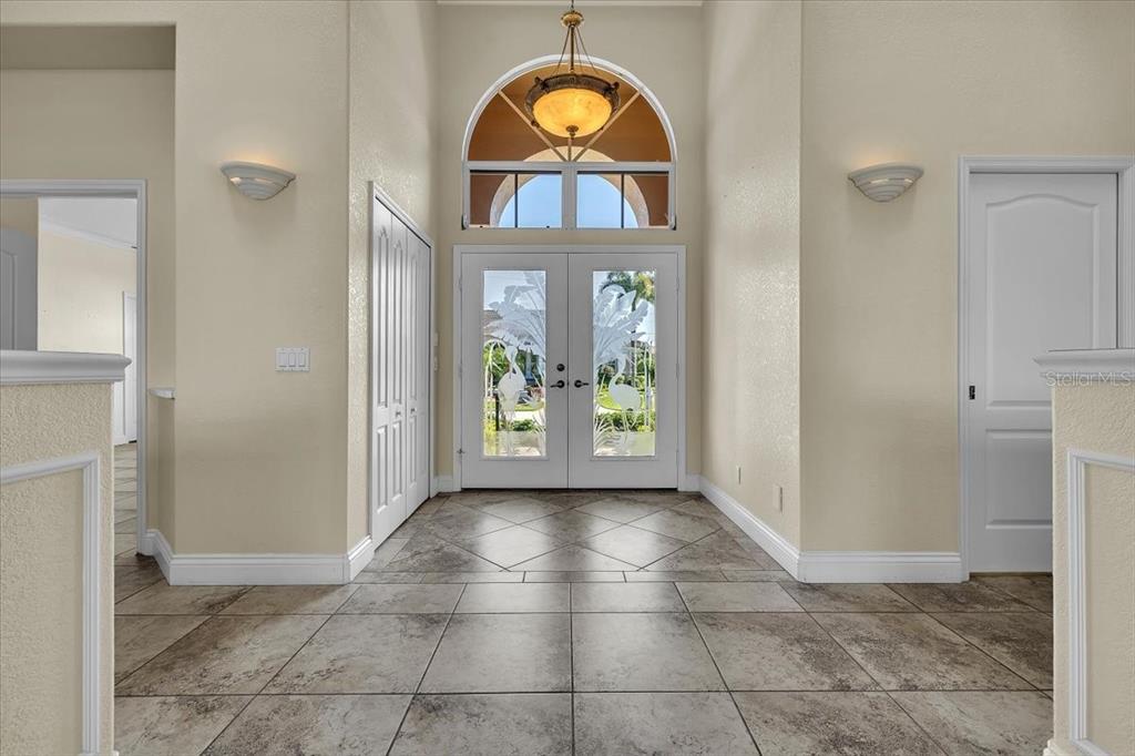 A tiled entryway features a double front door with etched glass and a high arched window — 3651 ARUBA COURT, PUNTA GORDA, FL