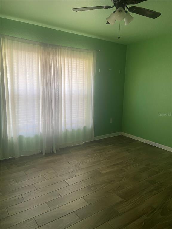 A bedroom with green walls, wood-look tile flooring, and a ceiling fan — 6775 HIGHLANDS CREEK LOOP, LAKELAND, FL