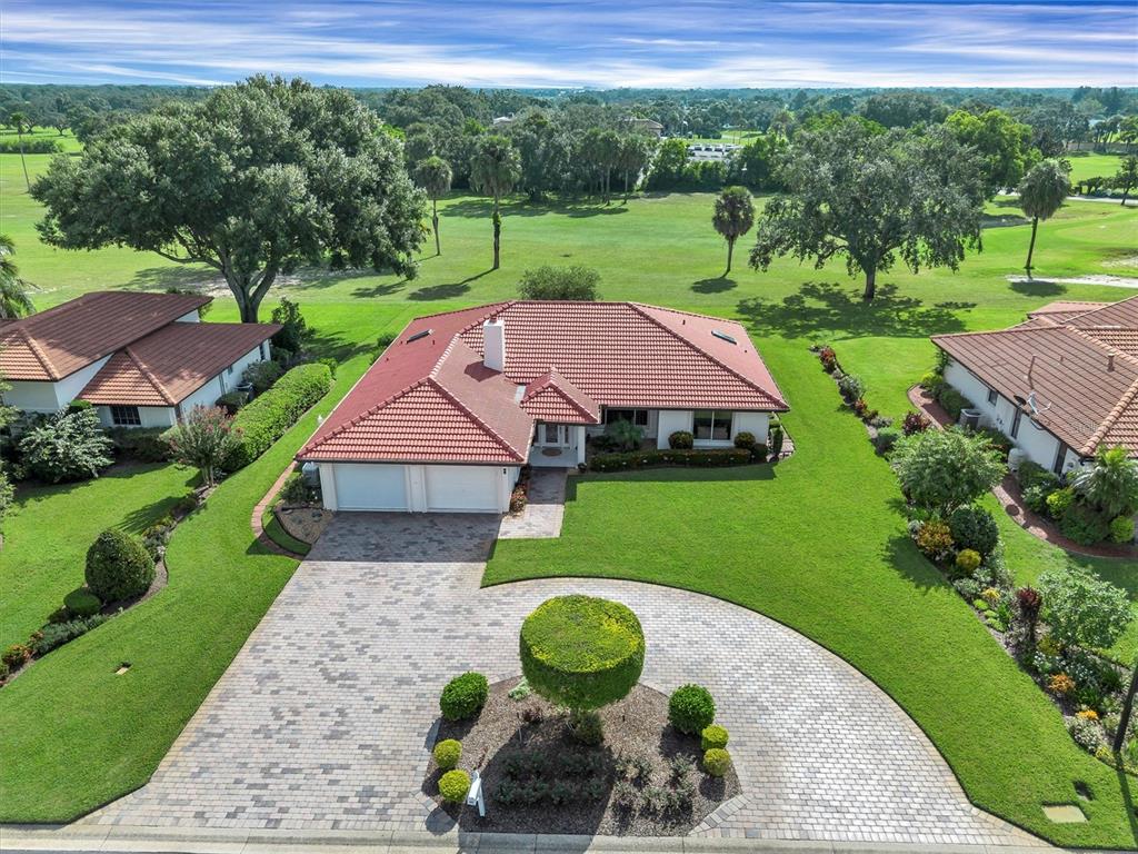 An aerial view shows a single-story house with a red tile roof and paved driveway — 517 CLUBHOUSE DRIVE, LAKE WALES, FL