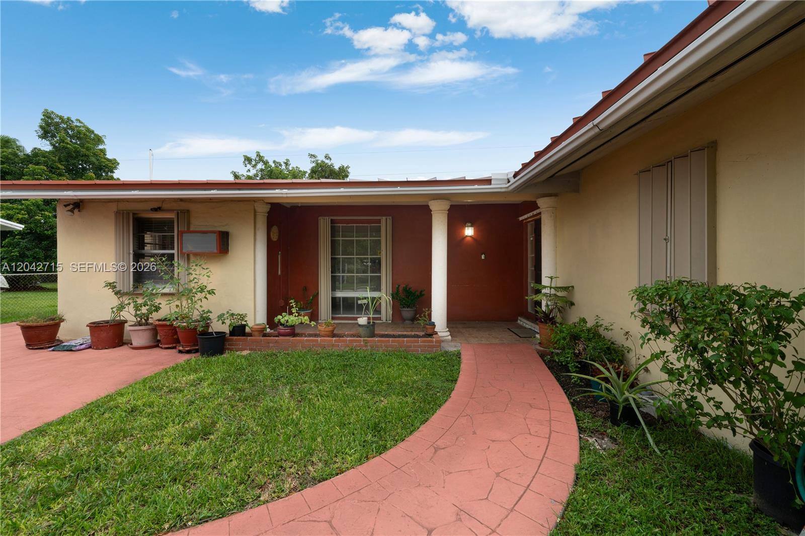 A red walkway leads to the covered entrance of a house with a lawn — 10315 SW 200th St, Cutler Bay FL 33157, CUTLER BAY, FL