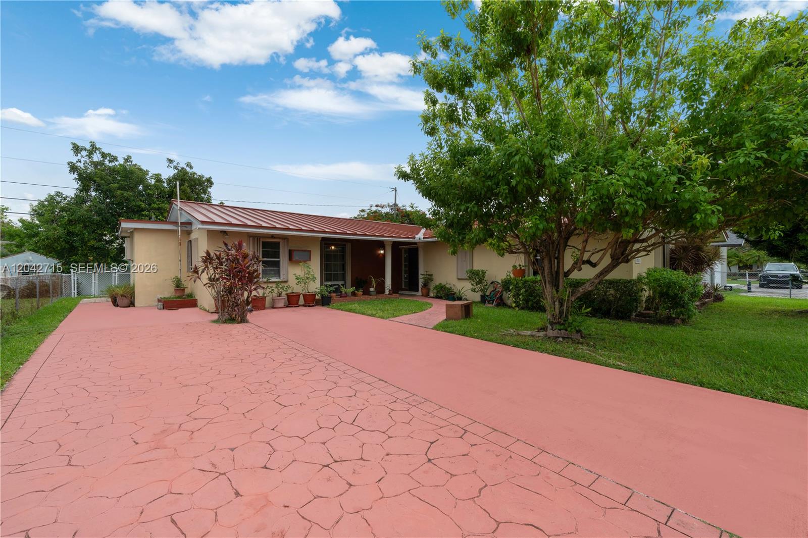 A single-story house with a red metal roof and a stamped concrete driveway — 10315 SW 200th St, Cutler Bay FL 33157, CUTLER BAY, FL