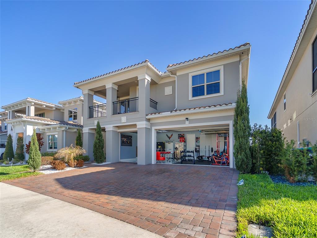 A two-story house with a brick driveway and a garage converted into a home gym — 13759 LARKTON LANE, ORLANDO, FL