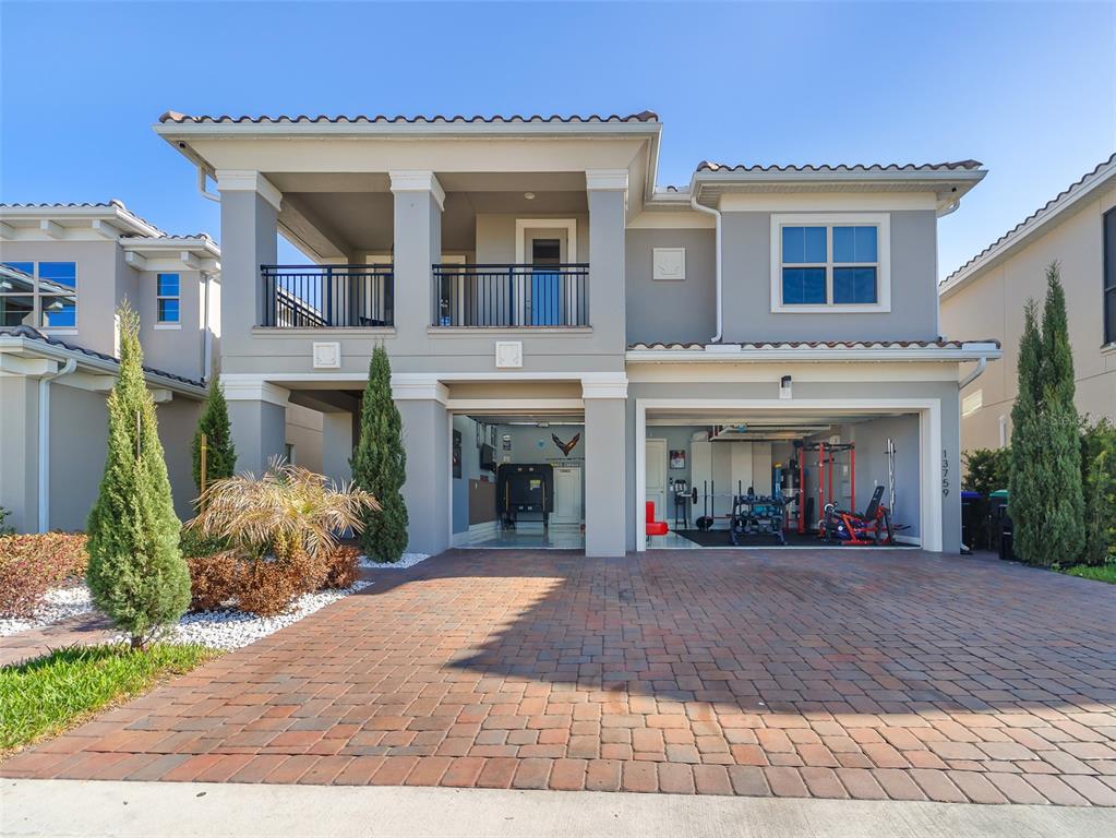 A two-story house with a paved driveway, a two-car garage gym, and an upper balcony — 13759 LARKTON LANE, ORLANDO, FL