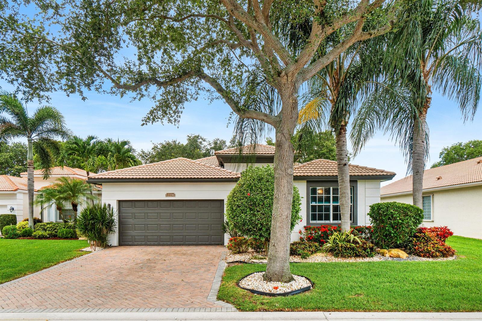 A single-story house with a brown garage door, tiled roof, and a large front tree — 12196 Landrum Way, Boynton Beach FL 33437, BOYNTON BEACH, FL