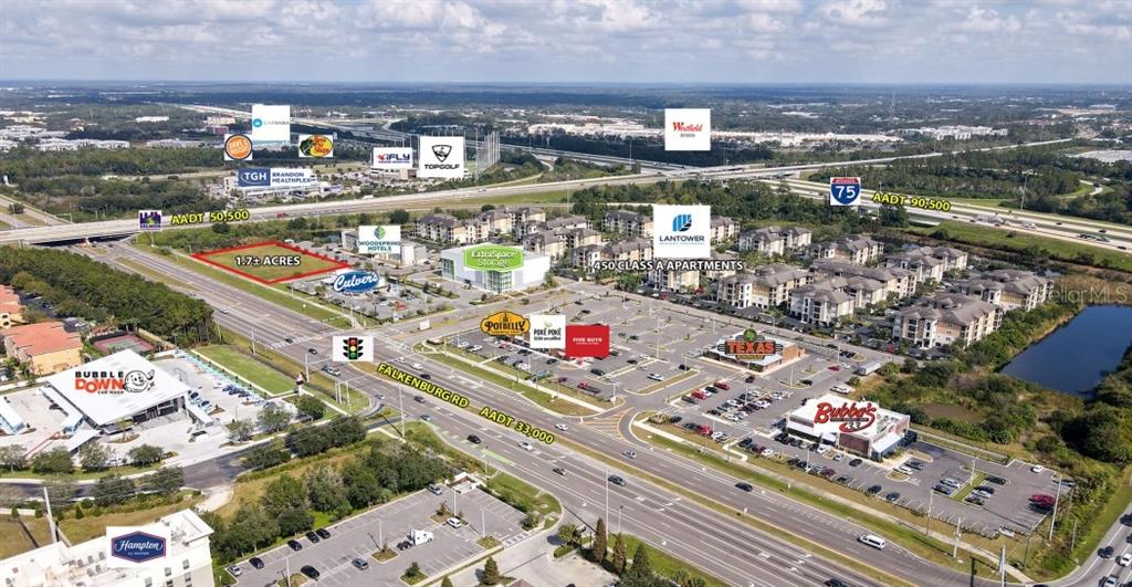 This aerial view shows a commercial development site with surrounding businesses and highway access — 2478 FALKENBURG ROAD, BRANDON, FL