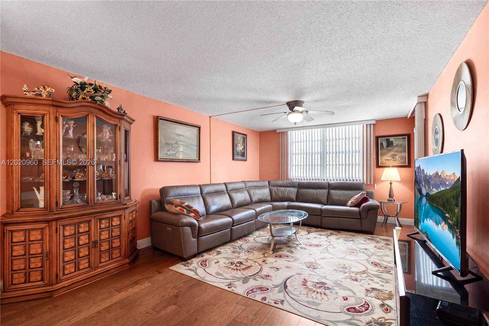 A living room features a brown leather sectional, a glass coffee table, and a wooden cabinet — 1849 S Ocean Dr # 305, Hallandale Beach FL 33009, HALLANDALE BEACH, FL