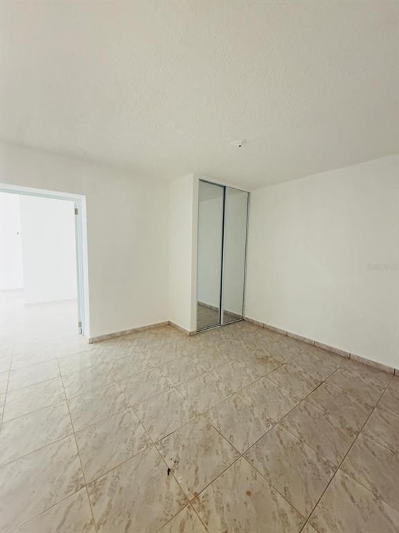 An empty room features white walls, tiled flooring, and a closet with sliding mirrored doors — 763 SAN SALVADOR, CAGUAS, PR