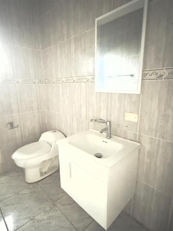 A bathroom features a white vanity with a sink, a toilet, and a wall mirror — 763 SAN SALVADOR, CAGUAS, PR