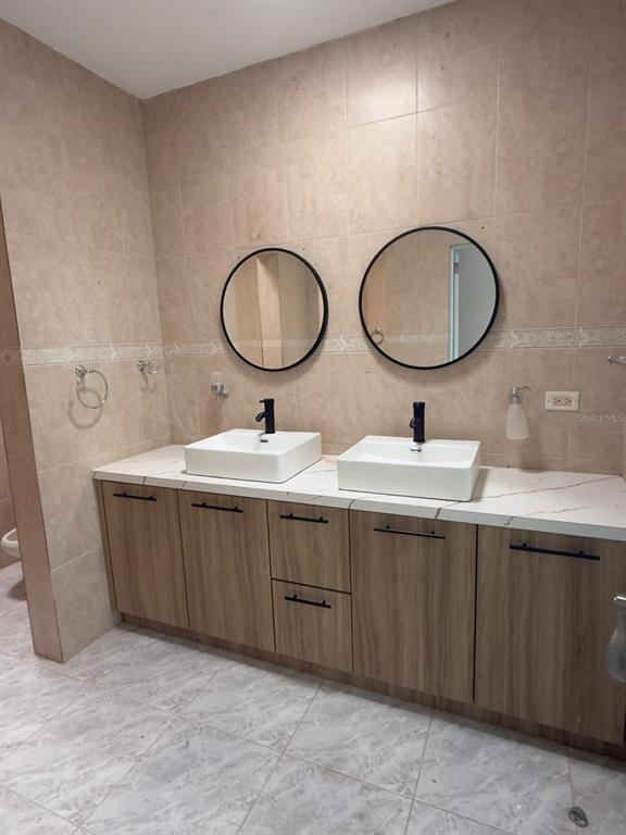 A bathroom features a double vanity with white vessel sinks, black faucets, and round mirrors — 763 SAN SALVADOR, CAGUAS, PR
