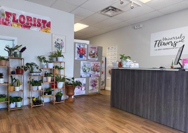 A florist shop interior features a wooden reception desk, display shelving with plants, and signage — 120 ALEXANDRIA BOULEVARD UNIT 17, OVIEDO, FL