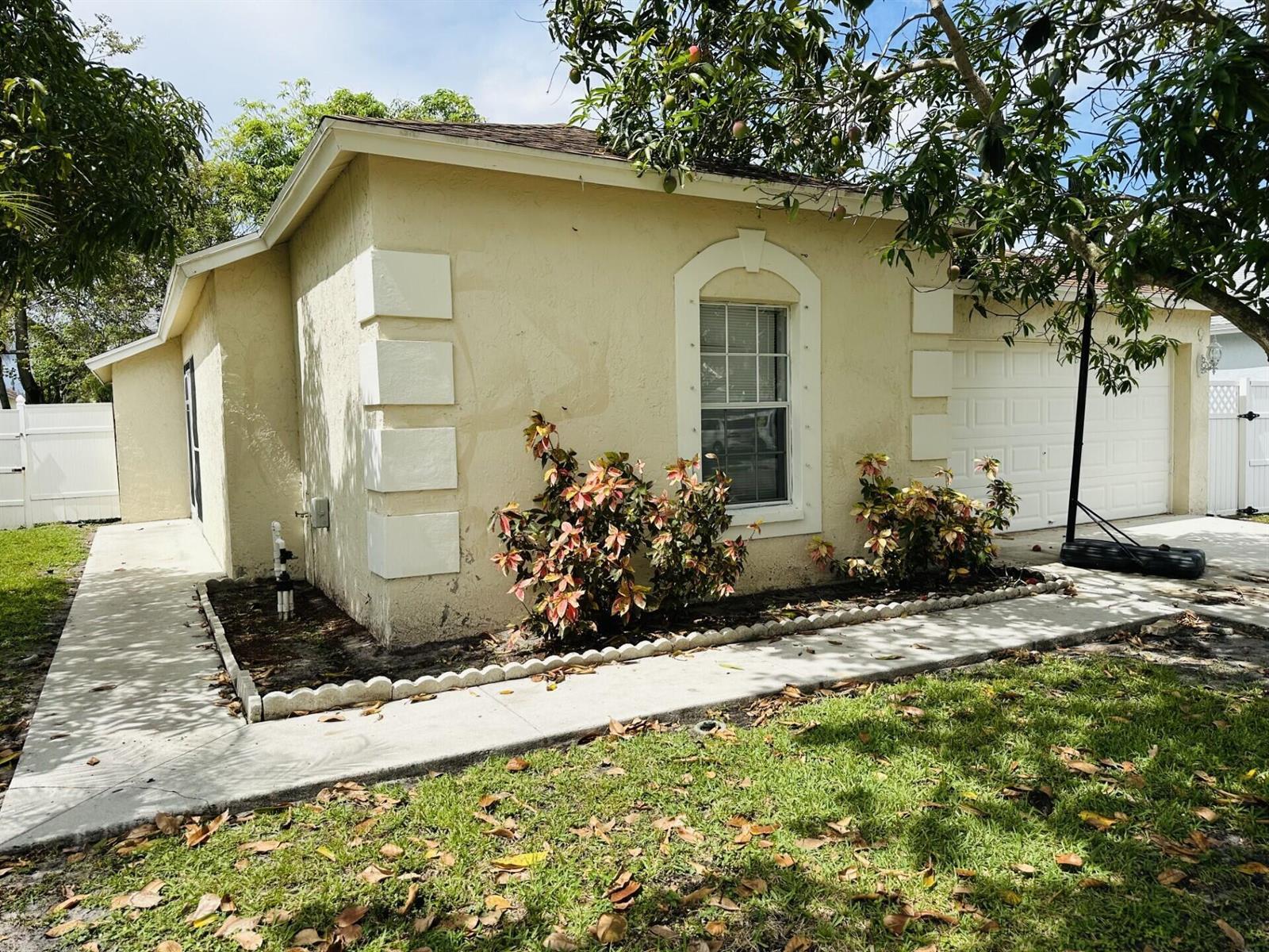 A stone retaining wall sits in front of a beige sign reading Foxhall — 5165 Foxhall Pl, West Palm Beach FL 33417, WEST PALM BEACH, FL