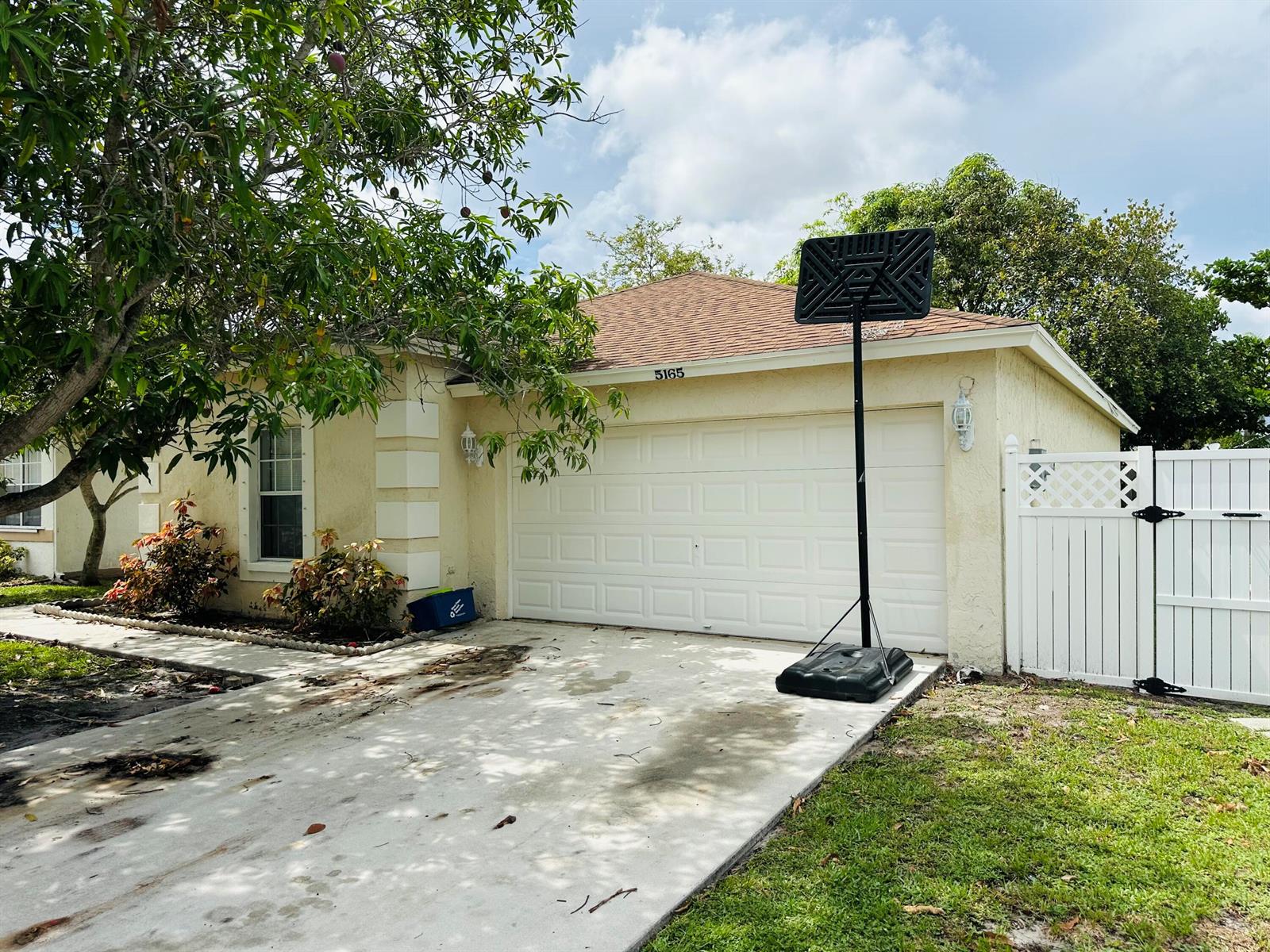 A kitchen features dark wood cabinets, granite countertops, stainless steel appliances, and light tile flooring — 5165 Foxhall Pl, West Palm Beach FL 33417, WEST PALM BEACH, FL