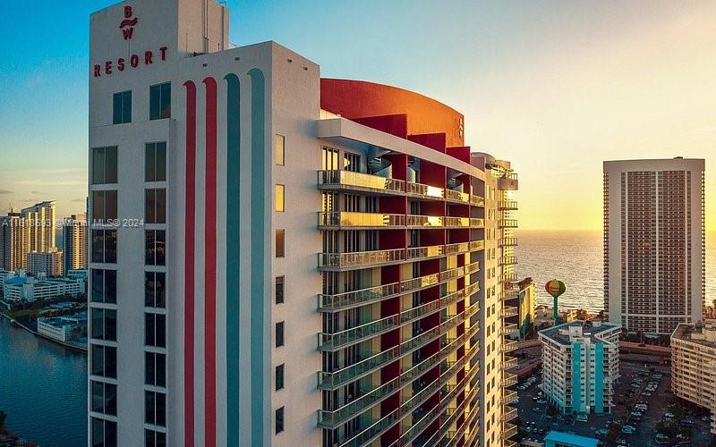 An aerial view of a tall, modern resort building with balconies overlooking the ocean — 2602 E Hallandale Beach Blvd # R807, Hallandale Beach FL 33009, HALLANDALE BEACH, FL